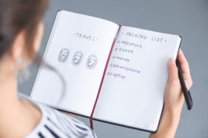 Woman holding a pen writing notes in a book