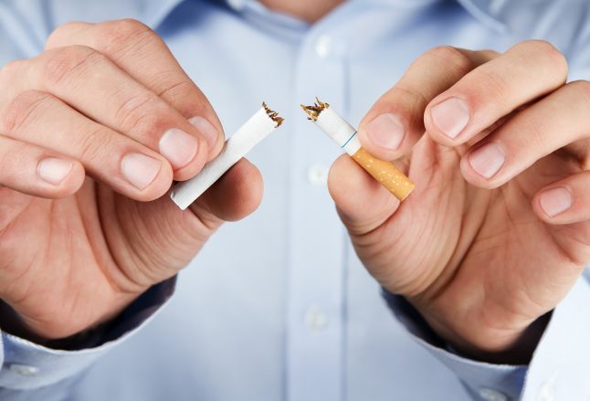 Human hands breaking up cigarette