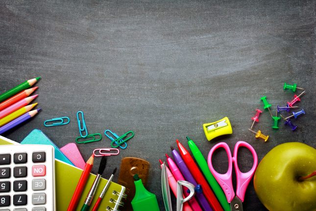 School supplies on blackboard background ready for your design