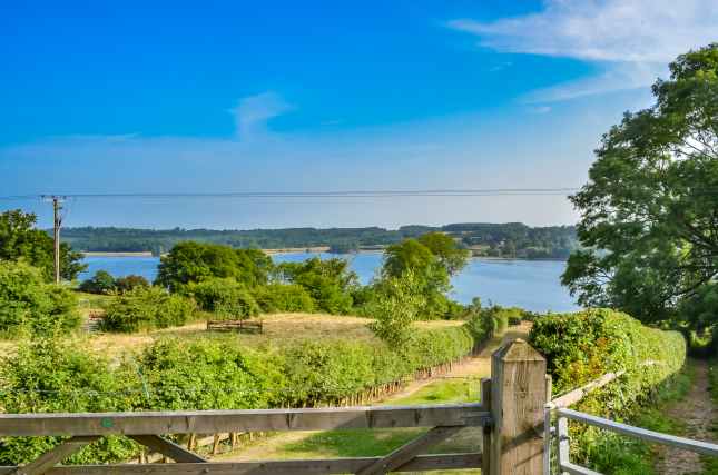 View over a gate towards Rutland Water a large reservoir in Leicestershire