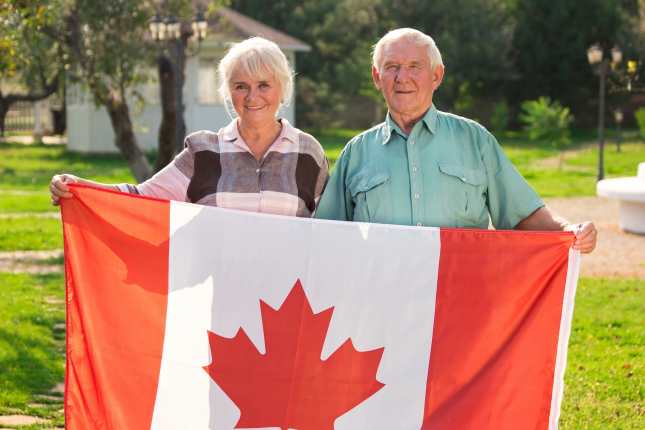 Elderly Couple Holding Canada Flag